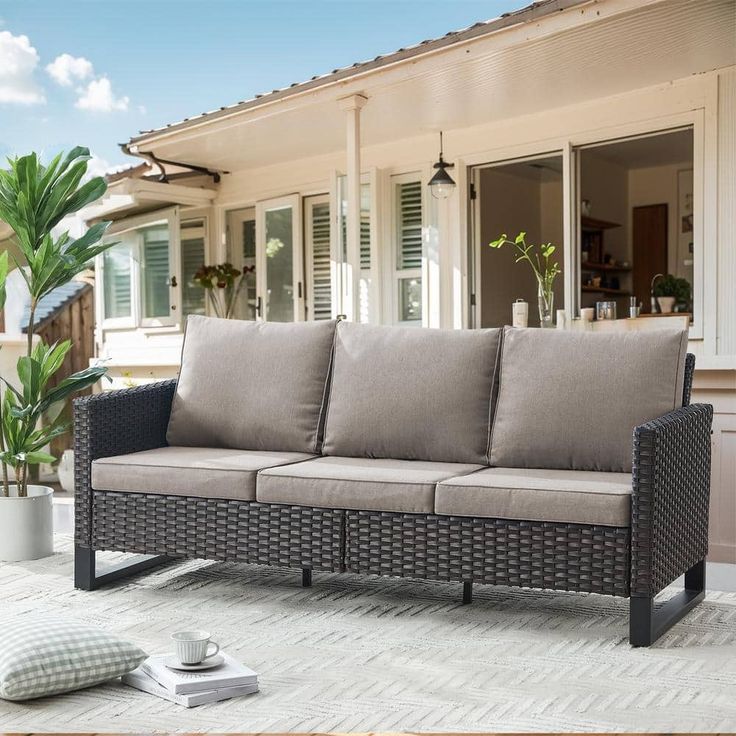 a couch sitting on top of a patio next to a house