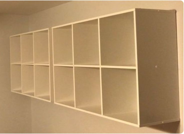 an empty room with white shelving units on the wall and no one in it