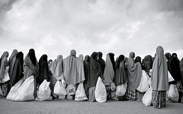 a group of people standing in the middle of a road with bags on their backs