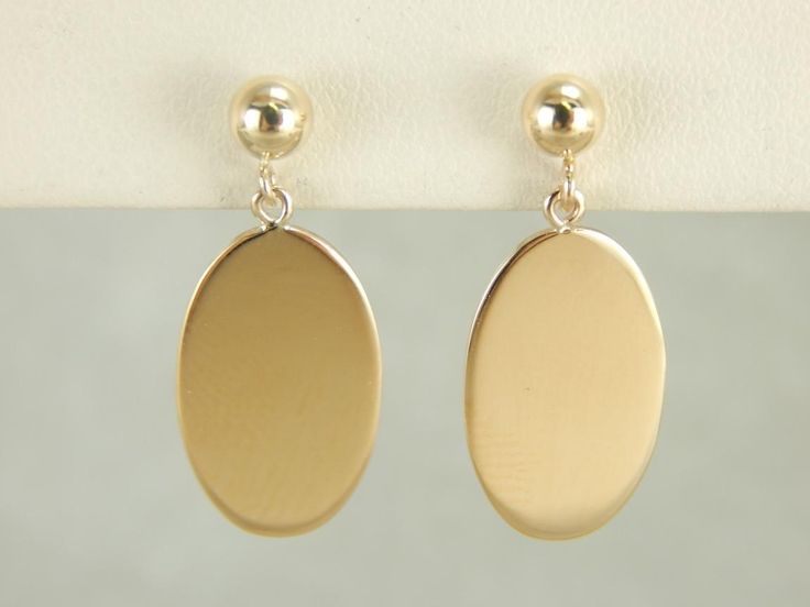 Beautifully polished and simple as can be in design. These gleaming yellow gold drops were adapted from a pair of antique cufflinks, and hung from simple stud earrings. Metal: 14K Yellow Gold Earrings Length: 22 mm Earring Width: 9 mm Marks: "14K" Stamped on the findings Cheap Oval Yellow Gold Earrings, Elegant Oblong Earrings For Pierced Ears, Minimalist Oblong Earrings For Formal Occasions, Classic Oblong Jewelry With Polished Finish, Yellow Gold Oblong Earrings For Gift, 14k Gold Oblong Earrings As Gift, Oblong Yellow Gold Earrings For Gift, 14k Gold Oblong Earrings For Gift, Gold Oblong Earrings For Formal Occasions