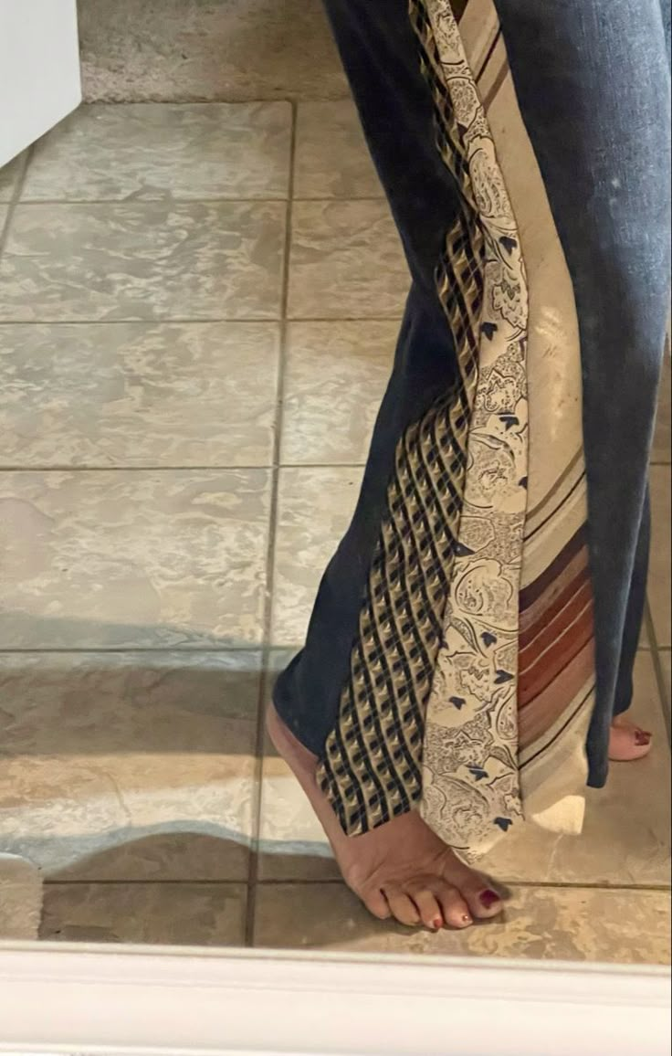 a woman's legs are seen through a mirror in her jeans and flip flops