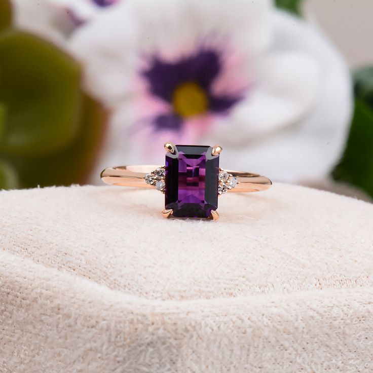 a ring with an amethyst purple stone in it sitting on a white towel