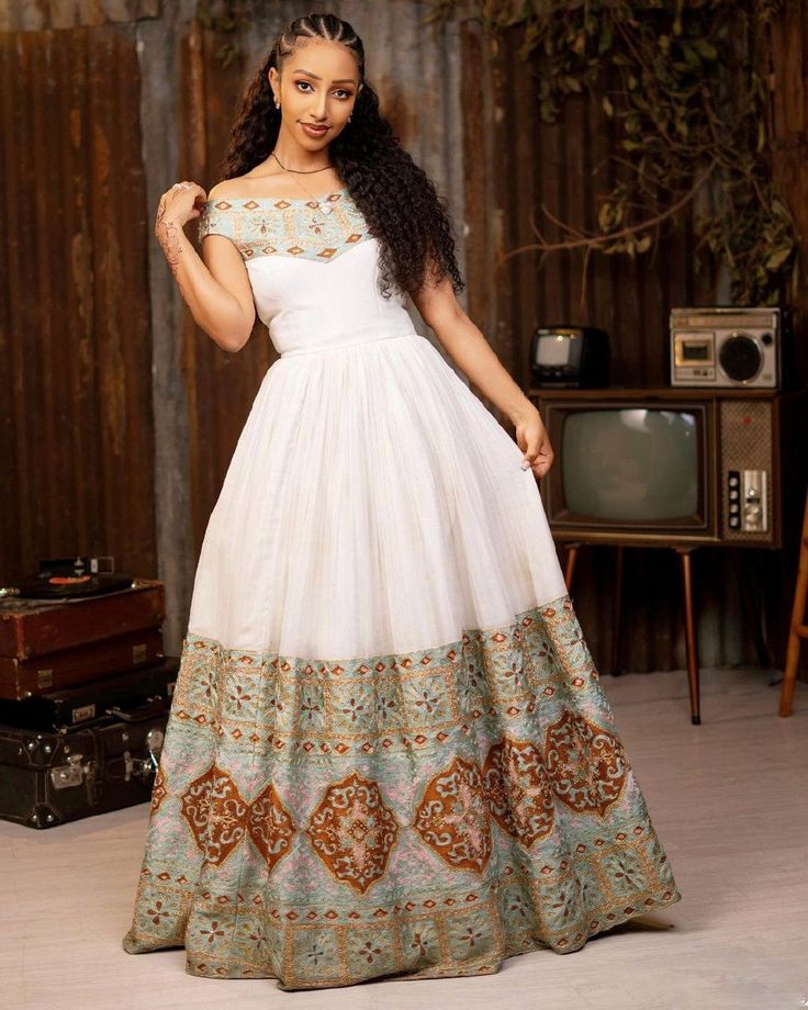 Experience the ultimate in bridal beauty with our gorgeous wedding Habesha dress. This exquisite Habesha Kemis is a stunning example of Ethiopian traditional dress, perfect for making your special day truly unforgettable. With its intricate design and elegant details, this dress embodies grace, tradition, and timeless elegance. Material Cotton Menen Thread Estimated delivery : 2 weeks to 3 weeks Contact WhatsApp +1(304)-306-2784Email: contact@ethiopian.store White Bollywood Style Traditional Drape Dress, White Bollywood Dress For Reception, Bollywood Style White Dress For Reception, White Floor-length Dresses With Cutdana, Maxi Length Embroidered Dress For Wedding And Navratri, Maxi Length Embroidered Wedding Dress For Navratri, Floor-length Dresses With Intricate Embroidery For Navratri, Bohemian Floor-length Dress With Cutdana, Semi-stitched Wedding Dresses