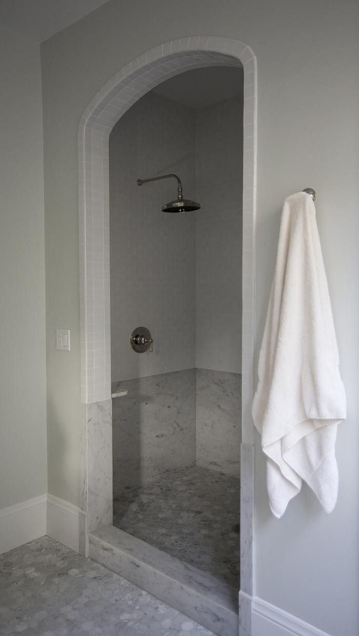 a white towel hanging on the wall next to a shower