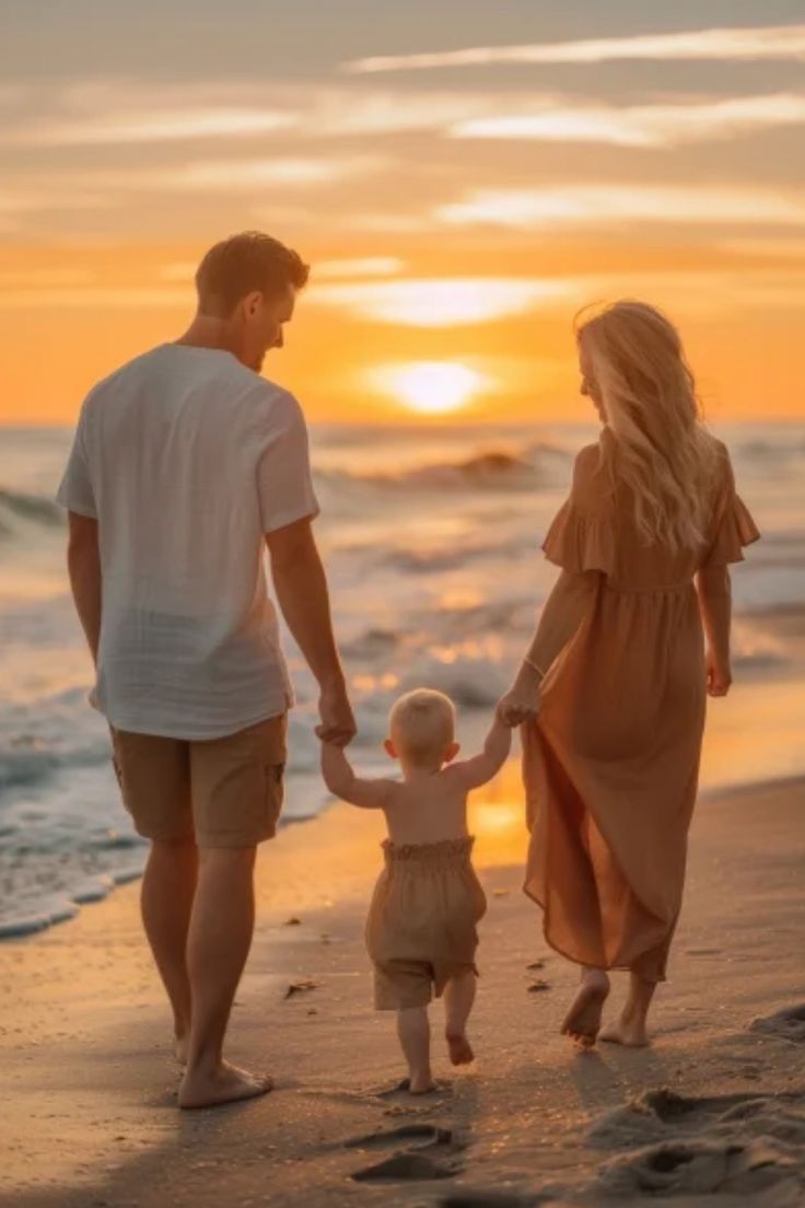 a family walking on the beach at sunset