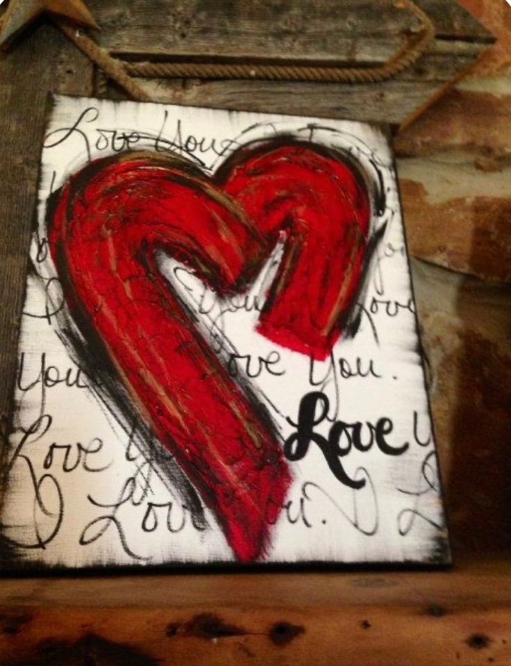 a red heart painted on top of a piece of wood