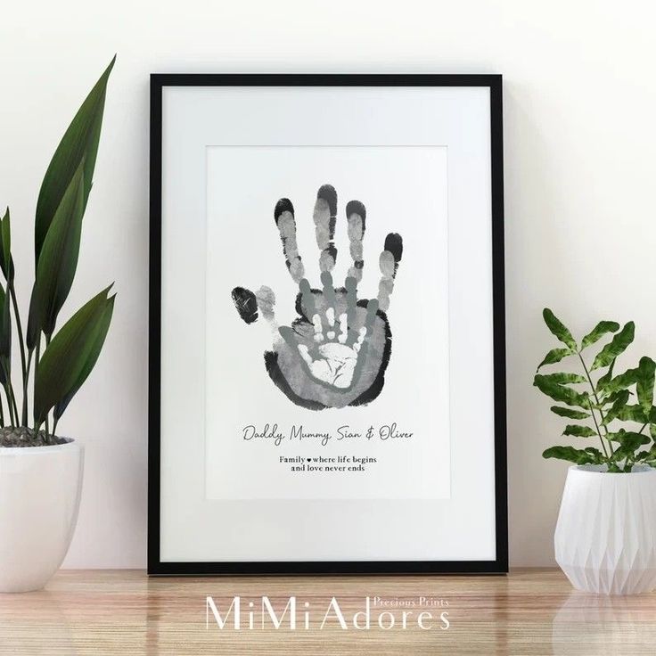 a black and white hand print on a shelf next to a potted plant