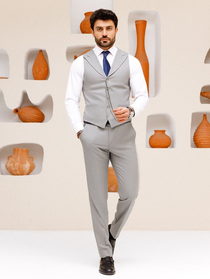 This grey 3-piece slim-fit suit is the epitome of sophistication and style. The jacket features wide lapels, creating a bold statement and showcasing a keen eye for detail. The vest, with its matching lapels, further elevates the aesthetic and provides a cohesive look. Upgrade your wardrobe with this standout piece and make a lasting impression at your next event. Color: grey Material: 60% wool, 30% polyester, 7 viscose, 3% elastane Suit includes blazer, waistcoat, & trousers Single-breasted sui Slim Fit Three-piece Suit For Business Casual, Semi-formal Slim Fit Three-piece Suit With Single Button, Slim Fit Three-piece Suit With Single Button, Slim Fit Professional Three-piece Suit, Professional Slim Fit Three-piece Suit, Professional Three-piece Slim Fit Suit, Fitted Gray Suit With Single Button, Gray Fitted Suit With Single Button, Semi-formal Slim Fit Three-piece Suit With Lapel Collar