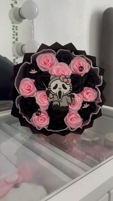 a black and pink flower box with a skull on it's face in front of a mirror