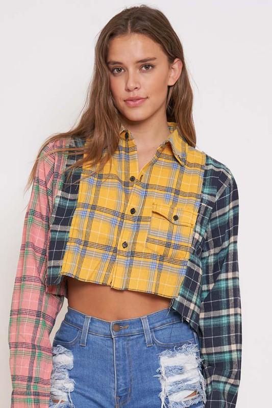 a woman wearing ripped jeans and a plaid shirt