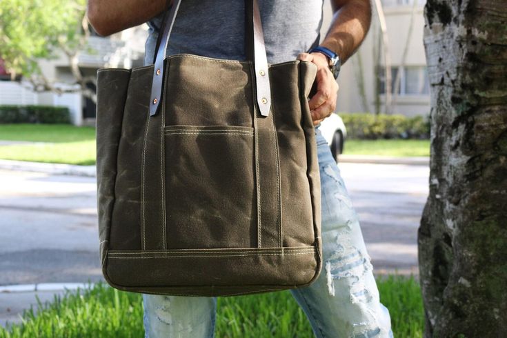 tote / carry all bag  All heavy duty waxed canvas and genuine leather accents.  This premium grade waxed canvas is water resistant. The material was carefully selected from the best textile supplier in the USA.  The handles are made of beautiful thick brown leather. S P E C S - dark brown leather handles and accents - American Heavyweight waxed 19 Oz. - shown in FIELD TAN WAXED CANVAS ( other options at checkout ) - 2 exterior deep pockets - 1 interior zippered compartment - 6 interior drop pock Duck Canvas Bag With Leather Patch For Everyday Use, Everyday Duck Canvas Bag With Leather Patch, Rugged Everyday Bag With Pockets, Everyday Waxed Canvas Bag With Pockets, Outdoor Large Capacity Duck Canvas Bag, Leather Patch Tote Bag For Everyday Use, Rugged Canvas Bags With Pockets, Cotton Canvas Bag With Leather Trim For Daily Use, Everyday Duck Canvas Bag With Leather Trim