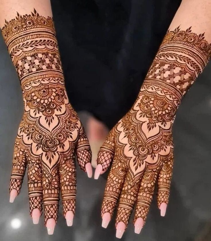 two hands with henna tattoos on them, one is showing the intricate pattern and the other