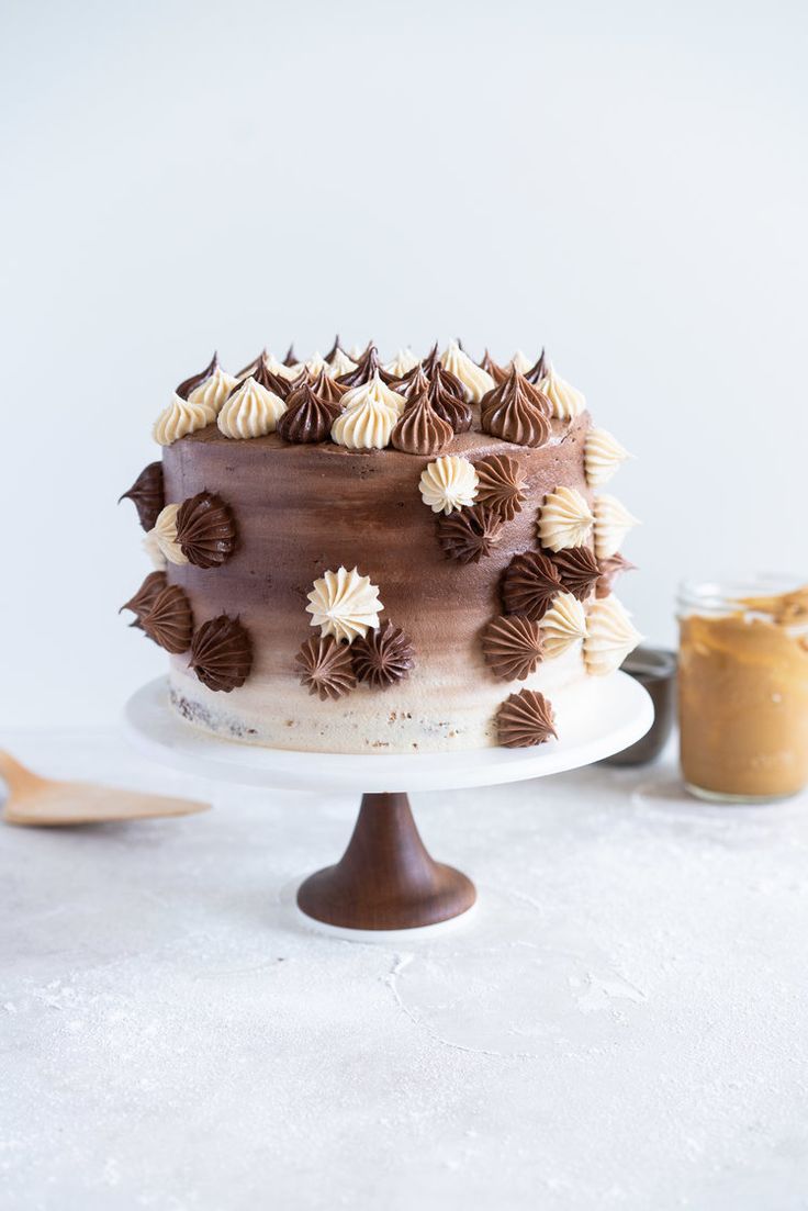 a chocolate cake sitting on top of a table next to a jar of peanut butter