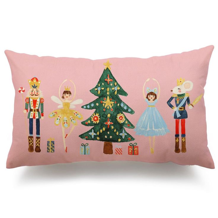 a pink pillow with nutcrackers, angels and a christmas tree on it