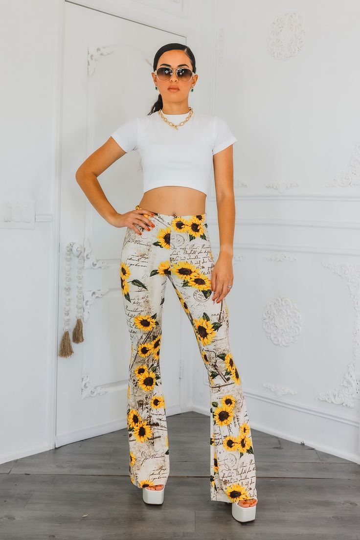 "Leave a love letter in every step with these buttery soft Sunflower Bell Bottom Pants. Flowing like a love letter, these pants offer unmatched comfort and style. Spread love with every wear. Spread good vibes (and fashion) with these bell bottoms!" Model is 5”4 and wearing 5 inch heels: wearing a size small. Great stretch. Trendy White Floral Print Pants, Trendy Printed Bottoms With Relaxed Fit, Trendy Relaxed Fit Printed Bottoms, Floral Print High-waisted Lounge Pants, Casual Stretch Bottoms With Floral Print, High Waist Floral Print Bottoms For Loungewear, High Waist Floral Print Loungewear Bottoms, Trendy Stretch Bottoms With Floral Print, Trendy Long Bottoms With Floral Print