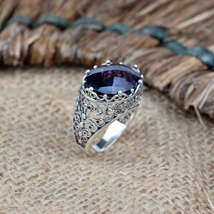 Elevate your style with our Handcrafted Sterling Silver Dome Cocktail Ring, a true masterpiece of filigree artistry. Meticulously crafted from 925 sterling silver, this ring exudes timeless elegance. Adorned with a mesmerizing 13x18 mm cabochon or faceted oval cut gemstone, you have the choice of the enchanting Rhodonite, the captivating Purple Mohave Turquoise, or the regal Amethyst. The ring face length is 0.80 inches and the width is 0.60 inches  Each gemstone tells a unique story: Rhodonite symbolizes love and compassion, Purple Mohave Turquoise represents balance and tranquility, and Amethyst embodies peace and clarity. With 16 different sizes available, ranging from a delicate size 5 to a bold 12.5, including half sizes, finding the perfect fit is effortless. Celebrate life's special Bohemian Oval Jewelry With Accent Stones, Ornate Sterling Silver Amethyst Gemstone Ring, Ornate Sterling Silver Amethyst Ring, Bohemian Sterling Silver Jewelry With Accent Stones, Sterling Silver Filigree Ring With Gemstone, Ornate Ring Jewelry With Accent Stones, Wedding Amethyst Ring With Large Stone In Sterling Silver, Wedding Amethyst Ring With Large Stone, Vintage Silver Rings With Gemstone Accents