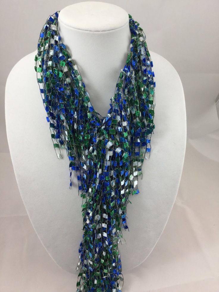 A beautiful and unique handmade accessory that shimmers and portrays a beaded look! Each Fringed Scarf Necklace is handmade and can be worn multiple ways. Item is lite weight and is available in many stunning great colors. Comes packaged in an organza bag. A great gift item. Fringed Scarf Necklace is approx. 66 inches in length and is made of 97% Nylon and 3% Lurex. Handwash in cold water and lay flat to dry. Each item is made by hand and slight variations may occur. Turquoise Beaded Chain For Party, Turquoise Multi-strand Necklace For Party, Adjustable Blue Beaded Necklaces For Party, Unique Beaded Party Necklaces, Blue Long Beaded Necklaces For Party, Blue Long Beaded Necklace For Party, Blue Long Necklace For Party, Blue Beaded Chain Lariat Necklace, Handmade Lariat Beaded Necklace For Party