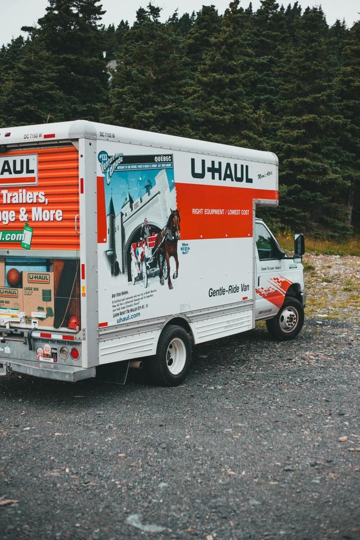 a moving truck is parked on the gravel