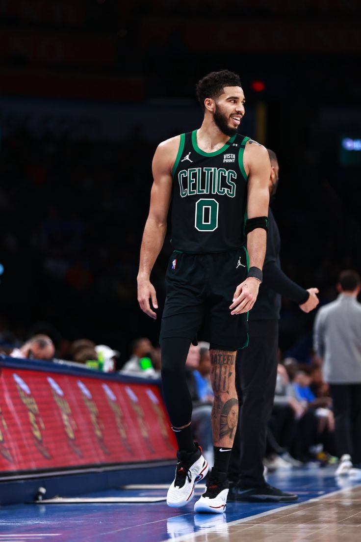 a basketball player is standing on the court with his foot up and looking at something