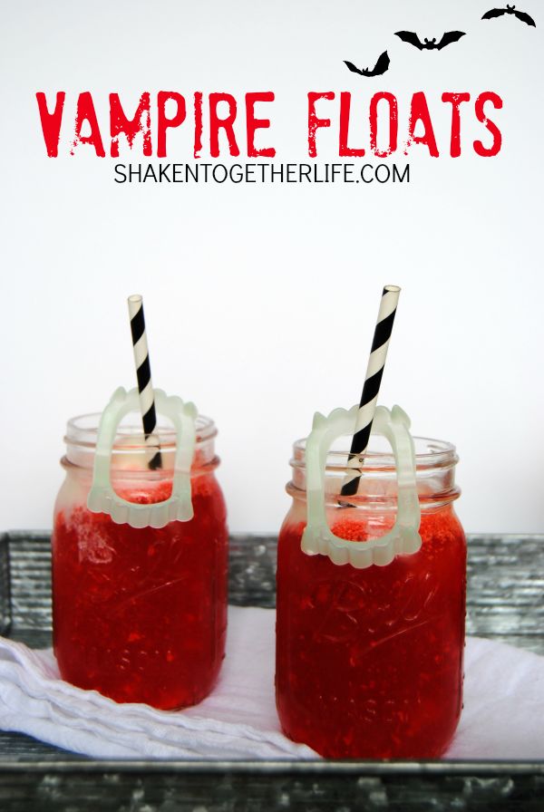 two mason jars filled with red liquid and topped with black and white striped straws