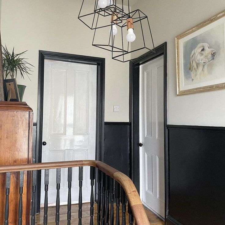 an entry way with two doors and a chandelier hanging from it's ceiling