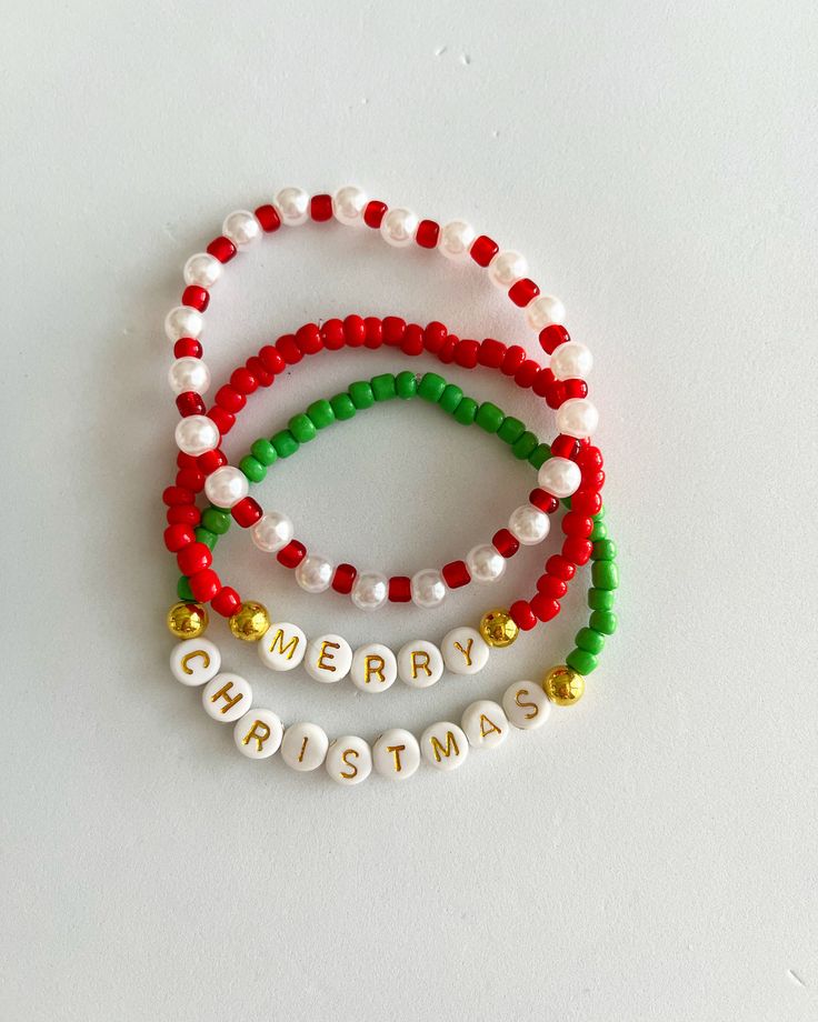 three beaded bracelets with merry christmas written on them