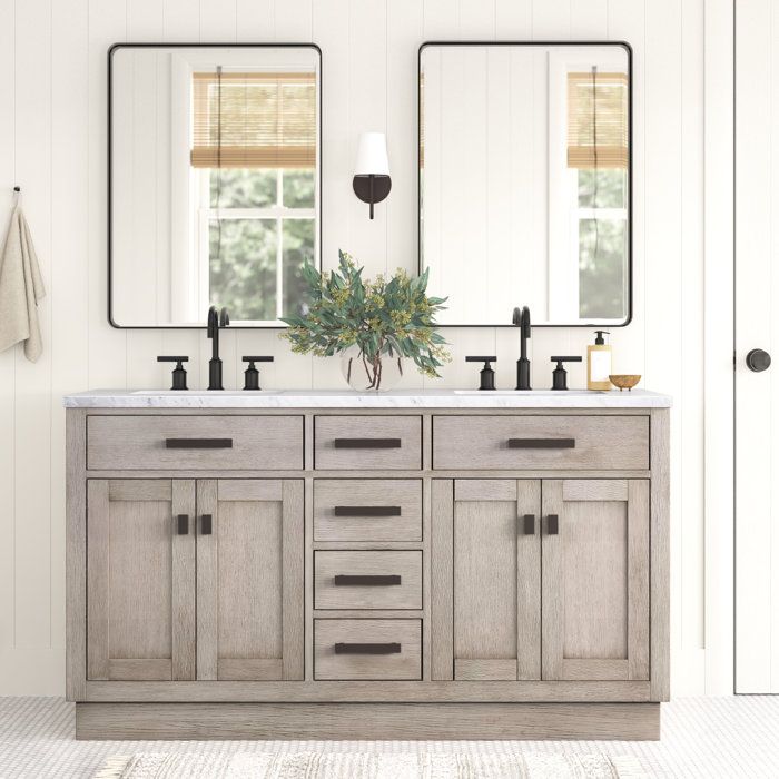 a bathroom vanity with two mirrors above it and a plant on the counter in front of it