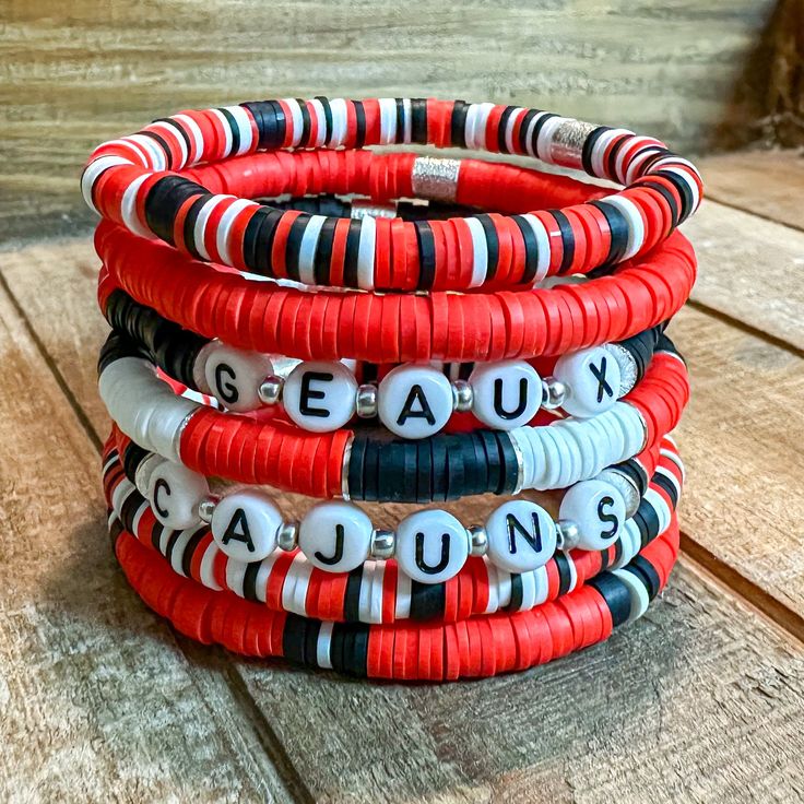 "Red, Black, and White Bracelet Stack - Perfect to pair with your game day attire! Mix and Match! Wear one or wear them all together! Geaux Cajuns!       Please Note:    When putting the bracelet on please \"roll\" it on. Stretching out the bracelet can cause it to change size over time.       Bracelets are 7\" in length. If a different size is needed please let me know." Cheap White Beaded Bracelets For Game Day, Red Smiley Face Clay Bracelet, Personalized Red Stretch Bracelet, Casual Style, Personalized Red Casual Wristband, Red Team Spirit Bracelets For Gifts, Red Personalized Bracelets For Team Spirit, Red Personalized Bracelets With Team Spirit Style, Personalized Red Bracelets For Team Spirit, Red Beaded Bracelets With Letter Beads For Game Day