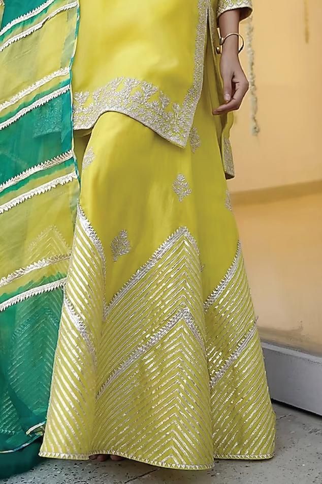 Lime yellow kurta in organza base with embroidery details. Paired with a matching chanderi sharara pant and a leheriya dupatta.
Components: 3
Pattern: Embroidered
Type Of Work: Zari
Neckline: Notched
Sleeve Type: Three-quarter
Fabric: Chanderi, Organza
Color: Yellow
Other Details: 
Attached lining
Kurta length: 38 inches
Model Height: 5ft 5inches, wearing size S
Occasion: Mehendi and Haldi - Aza Fashions Leheriya Dupatta, Yellow Kurta, Sharara Pants, Kurta Sharara Set, Kurta Sharara, Lime Yellow, Types Of Work, Sharara Set, Embroidery Details