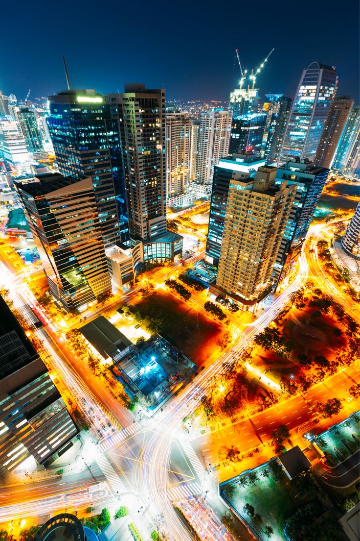 an aerial view of a city at night with lots of tall buildings and traffic lights