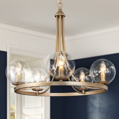 a chandelier with five clear globes hanging from it's brass frame