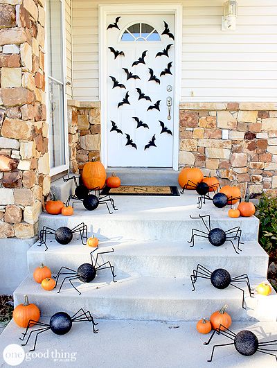 an image of halloween decorations on the front steps with bats and pumpkins around them