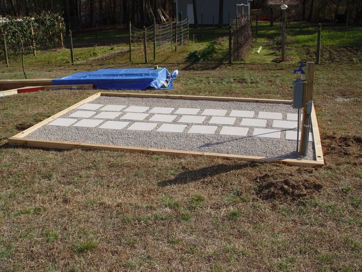 a concrete slab being laid out in the middle of a yard with an umbrella on top