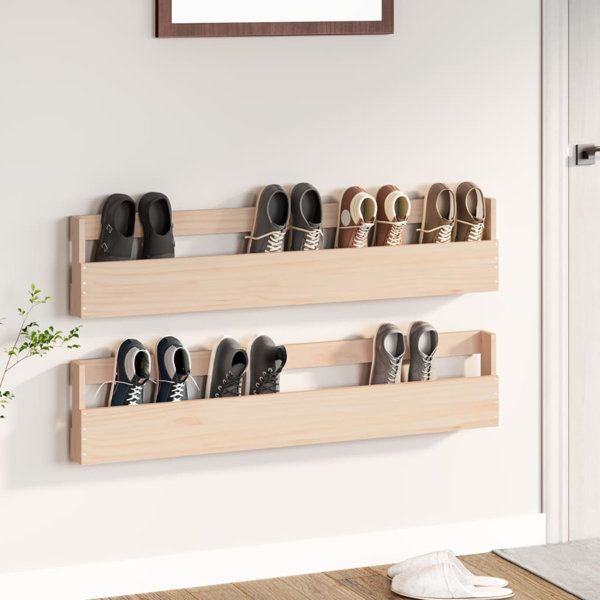 two wooden shelves holding pairs of shoes