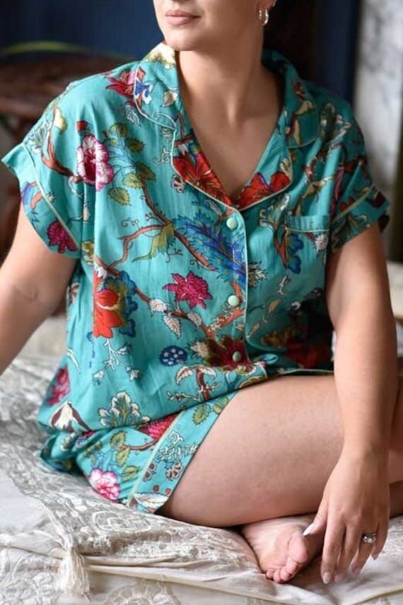 To See all our Pyjamas  please follow this link https://www.etsy.com/uk/shop/Kimonocoshop?ref=shop_sugg_market&section_id=29278259 These short cotton pyjamas in our vibrant prints are ideal for warmer nights. This beautiful print of multi-coloured exotic flowers against a vivid teal background will make bedtime fun and colourful. The short-sleeved jacket has a single breast pocket and fastens with fabric-covered buttons, and the shorts have an elasticated drawstring waist for comfort. A contrast Blue Printed Sleepwear For Lounging, Blue Floral Print Sleepwear, Blue Sets For Relaxation In Spring, Casual Blue Floral Print Sleepwear, Blue Summer Sleepwear For Home, Light Blue Summer Sleepwear For Home, Blue Floral Print Relaxed Fit Sleepwear, Blue Short Sleeve Matching Sleepwear Set, Blue Relaxed Fit Sleep Sets