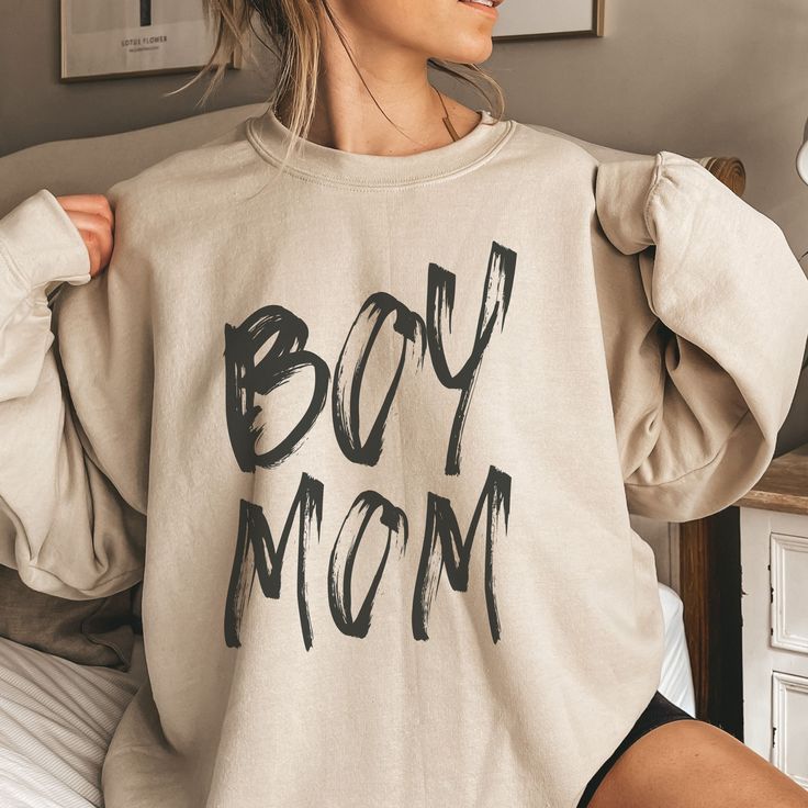 This adorable Boy Mom crewneck shows off your love of motherhood and chasing your boys around the playground or cuddling with them on the couch! This makes a perfect fall gift for the New Mom of Boys, Gender Reveal party, Mother's Day or Game Day. Gove the gift of a cozy sweatshirt to the Boy Mama in your life! Ideal for any situation, a unisex heavy blend crewneck sweatshirt is pure comfort. These garments are made from polyester and cotton. This combination helps designs come out looking fresh and beautiful. The collar is ribbed knit, so it retains its shape even after washing. There are no itchy side seams on these sweaters.  .: 50% cotton, 50% polyester .: Medium-heavy fabric (8.0 oz/yd² (271.25 g/m .: Loose fit .: Sewn-in label .: Runs true to size Boy Mom Shirt Ideas, Mom And Teen Son, Boy Mom Outfits, Mom Aesthetic Life, Boy Mama Shirts, Boy Mom Aesthetic, Boy Mom Sweatshirt, Aesthetic Mom, Gifts For New Mom