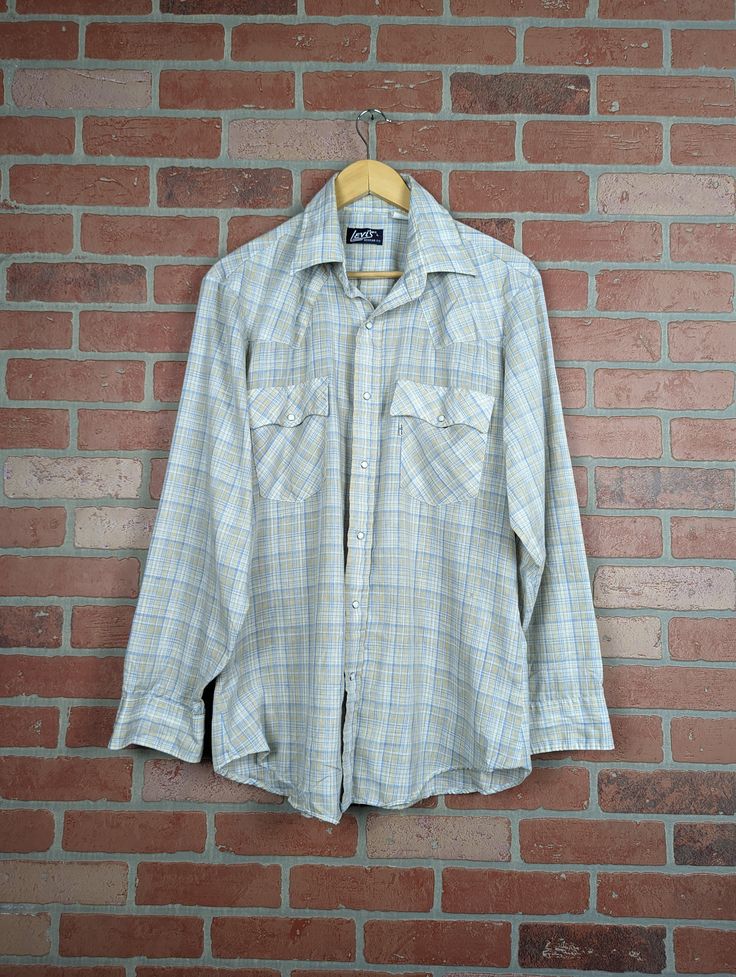 "Good condition on this piece from the70s. Chest (pit to pit) measurements: 24\" Length measurements: 31\" Tag: Levi's" Vintage Collared Flannel Shirt With Button Closure, Vintage Flannel Shirt With Pockets, Vintage Button-up Flannel Shirt With Snap Buttons, Retro Button-up Flannel Shirt, Vintage Snap Button Flannel Shirt, Retro Collared Flannel Shirt, Vintage Cotton Shirt With Snap Buttons, Vintage Cotton Flannel Shirt With Button Closure, Work Shirt