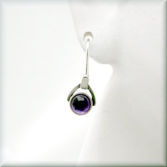 "Gorgeous amethyst cabochon earrings - a rich, deep purple that looks absolutely luscious. The setting is slightly oxidized sterling to make the stone really stand out. Beautiful for anyone who loves purple or as a gift for that person with a February birthday. The earrings are about 7/8\" long (2.2 cm) from top of earwire. Sterling silver. The amethyst cabochons are 5 mm in size. Jewelry is packaged in a cotton lined box for gift-giving. See more Bonny Jewelry at http://bonnyjewelry.etsy.com" Purple Round Pierced Earrings, Modern Cabochon Earrings For Gifts, Modern Cabochon Earrings Gift, Modern Purple Gemstone Earrings, Nickel-free Round Purple Earrings, Modern Amethyst Gemstone Earrings, Elegant Cabochon Adjustable Earrings, Modern Amethyst Earrings As Gift, February Gift