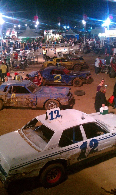 an old race car with numbers painted on it and people standing around in the background