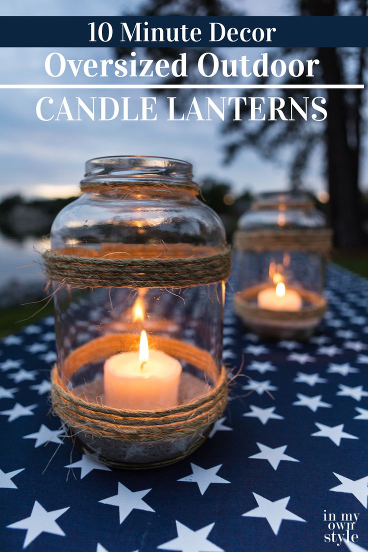 two mason jars filled with candles sitting on top of a blue and white table cloth