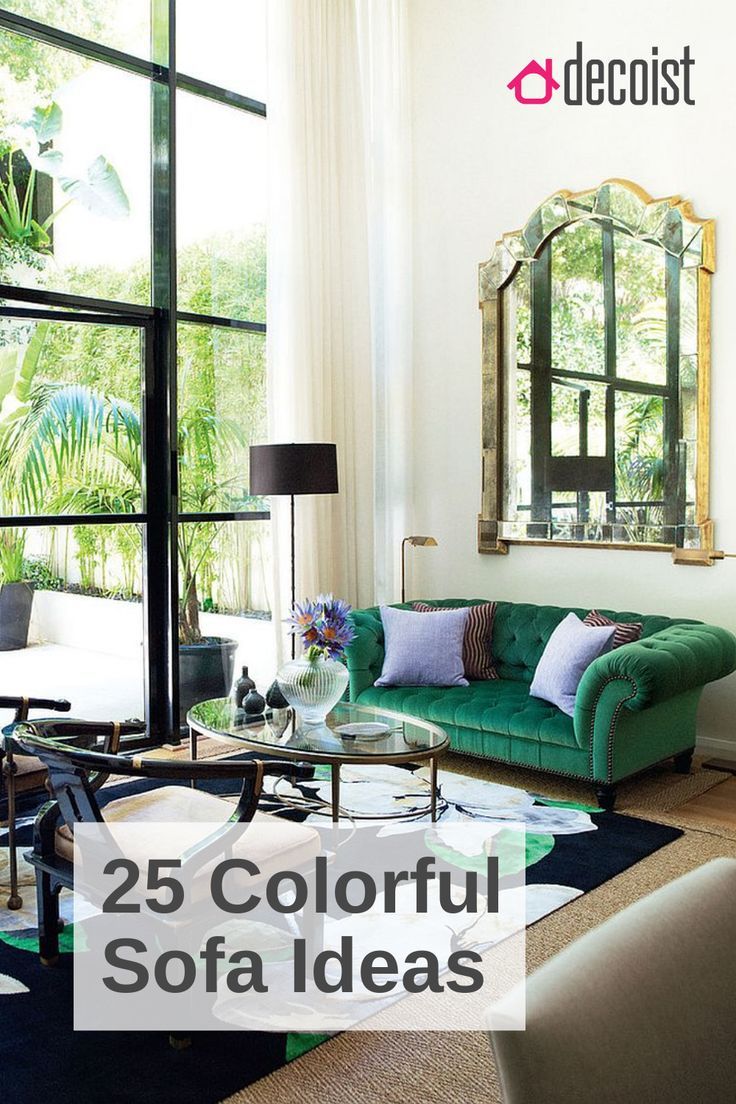 a living room with green couches and mirrors on the wall, in front of large windows