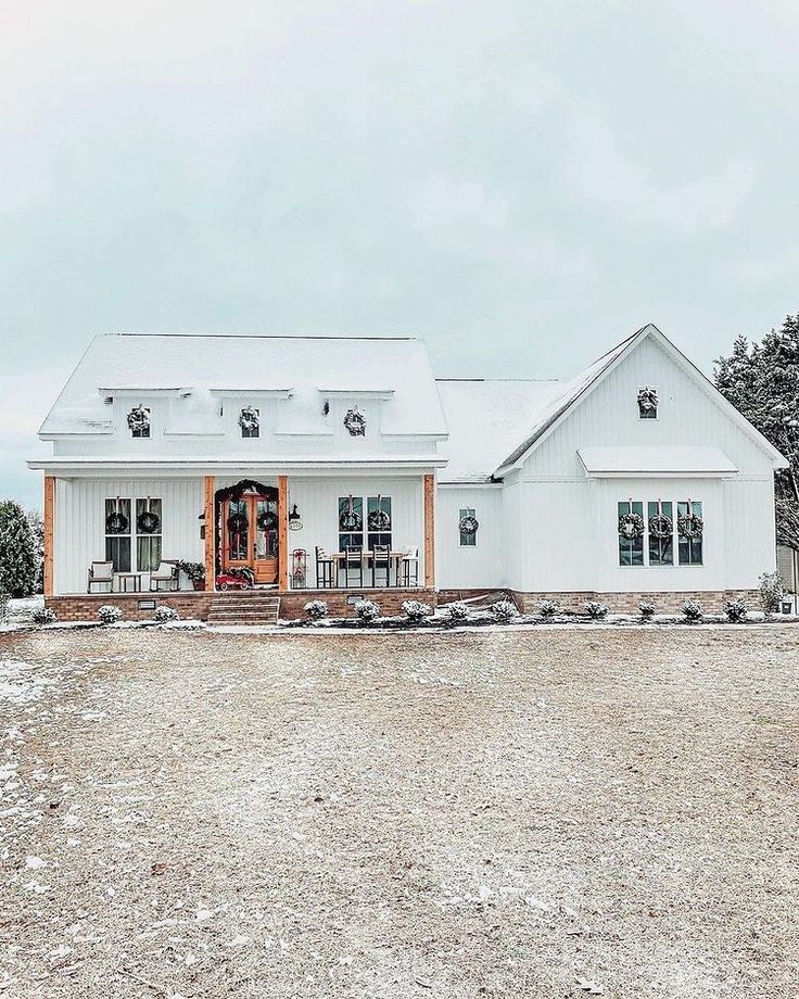 a large white house sitting on top of a snow covered field