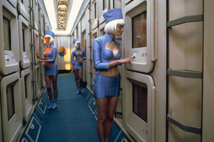 several women in blue uniforms are standing on an airplane aisle and looking out the windows