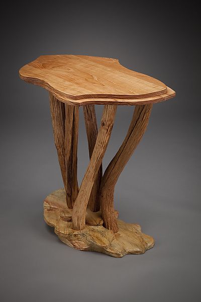 a wooden table with two trees on it's sides and one tree trunk at the base