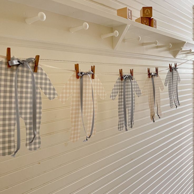 some clothes hanging on the wall in front of a white wall with wooden pegs