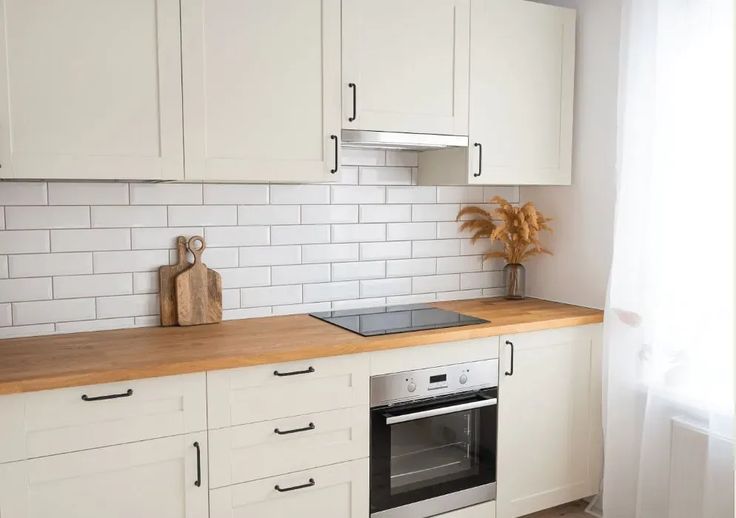 a kitchen with white cabinets and wood counter tops, including an oven in the center