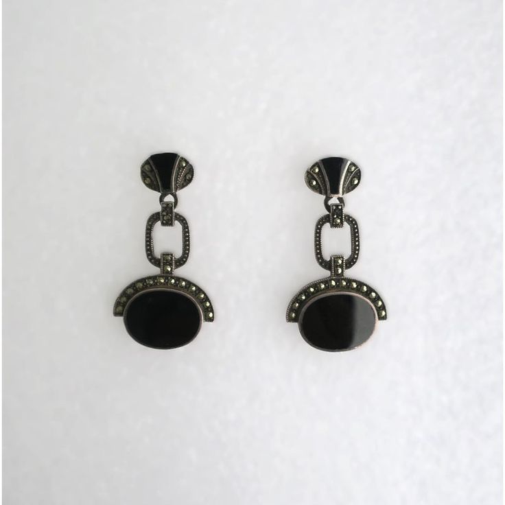 This is part of Chairish’s Fine Jewelry assortment.  A beautiful pair of black onyx and sterling silver Art Deco style dangle earrings, circa mid to late-20th century. A great pair to dress up or down. Each are marked on back 'Sterling' as shown in last three images. Excellent condition as shown in images. No issues. Dimensions: 1.5" Long. Classic Black Enamel Sterling Silver Earrings, Classic Sterling Silver Earrings With Black Enamel, Elegant Onyx Earrings With Polished Finish, Black Art Deco Earrings For Evening, Black Hallmarked Drop Earrings, Black Polished Evening Earrings, Black Polished Finish Earrings For Evening, Black Polished Earrings For Evening, Oval Sterling Silver Earrings For Evening