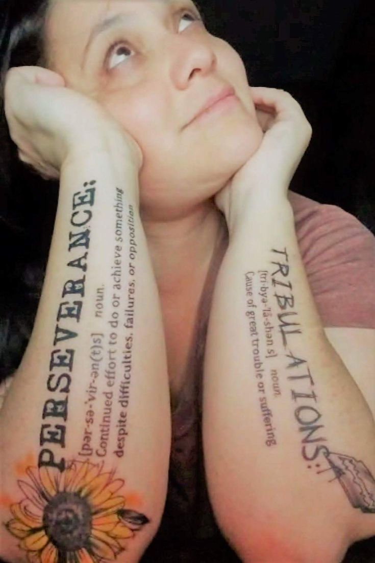 a woman with two tattoos on her arms and both have words written on their arms