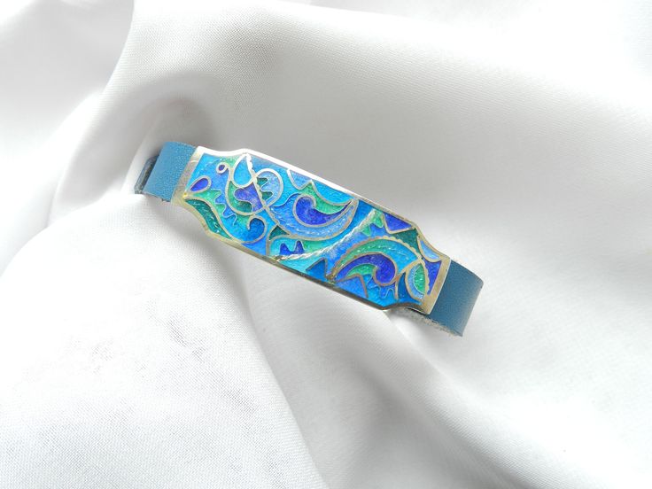 Georgian cloisonne enamel Bracelet on leather  - Fine silver jewelry, statement jewelry This jewelry is 100 % handmade by me in my studio. The technique is called Cloisonne enamel which is well known in Georgia. Many people in my country love buying handmade jewelry because they are unique and special!  ▪️ ▪️ ▪️ About shipping▪️ ▪️ ▪️ The price for this item includes standard shipping cost. Estimated arrival time: 3-4 weeks. ▪️ Delays might occur due to the current situation worldwide. So, pleas Modern Blue Leather Jewelry, Elegant Patina Bracelets As Gift, Blue Leather Bracelet As Gift, Blue Leather Bracelet For Gifts, Blue Wearable Art Bracelet, Blue Enamel Bangle Bracelets, Adjustable Enamel Cuff Bracelet As Gift, Adjustable Enamel Cuff Bracelet For Gift, Elegant Blue Leather Jewelry