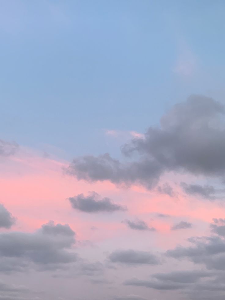 the airplane is flying high in the sky with clouds behind it and another plane on the ground